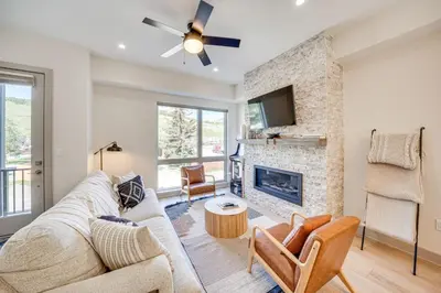 a living room with a couch and a fireplace at Rooftop Mtn View and Hot Tub Silverthorne Home! in Silverthorne