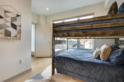 a bedroom with a bunk bed with a blue bedspread at Rooftop Mtn View and Hot Tub Silverthorne Home! in Silverthorne