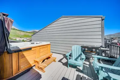 a deck with a bench and a chair and a grill at Rooftop Mtn View and Hot Tub Silverthorne Home! in Silverthorne