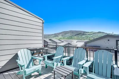a row of blue chairs sitting on a balcony at Rooftop Mtn View and Hot Tub Silverthorne Home! in Silverthorne