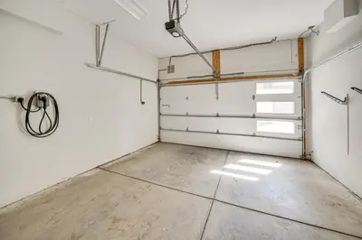 an empty garage with white doors and a concrete floor at Rooftop Mtn View and Hot Tub Silverthorne Home! in Silverthorne