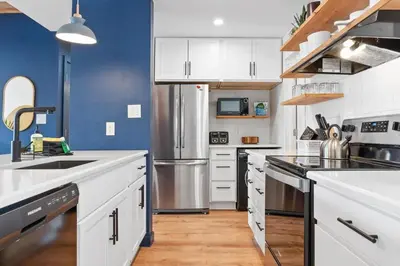 a kitchen with white cabinets and a blue wall at Stylish 2BR Near Trails and Slopes in Dillon