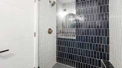 a bathroom with a shower with blue tiles at Stylish 2BR Near Trails and Slopes in Dillon