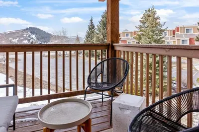 a porch with two chairs and a table and a balcony with snow at Stylish 2BR Near Trails and Slopes in Dillon