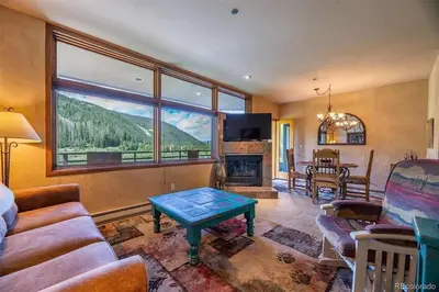 a living room with a couch and a table at Keystone W Magical View Walk to Ski Lift in Keystone