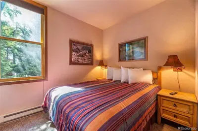 a bedroom with a bed and two windows at Keystone W Magical View Walk to Ski Lift in Keystone