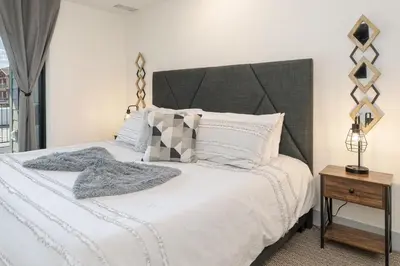 a bedroom with a large bed with white sheets and pillows at Ski Idlewild condo in Winter Park