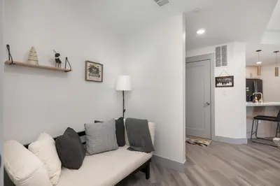 a living room with a white couch and a kitchen at Ski Idlewild condo in Winter Park