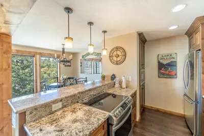 a kitchen with granite counter tops and a refrigerator at Lake Cliffe 303 Building E in Dillon