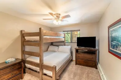 a bedroom with a bunk bed and a flat screen tv at Lake Cliffe 303 Building E in Dillon