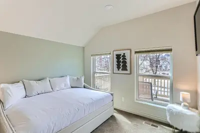 a bedroom with a white bed and two windows at 2226 N Washington St in Denver