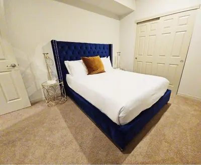 a bedroom with a large bed with a blue headboard at 2226 N Washington St in Denver