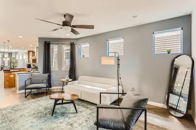 a living room with a white couch and a ceiling fan at 2226 N Washington St in Denver