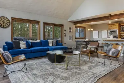 a living room with a blue couch and a table at Peaceful 5BR Retreat with Hot Tub in Breckenridge