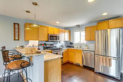 a kitchen with wooden cabinets and stainless steel appliances at 12 Mi to Denver Golden Vacation Rental! in Golden