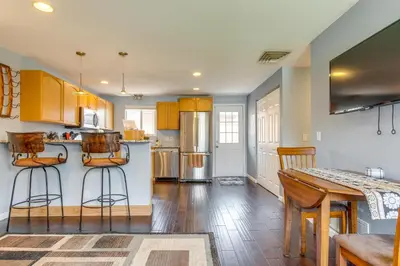 a kitchen with wooden cabinets and a table and chairs at 12 Mi to Denver Golden Vacation Rental! in Golden