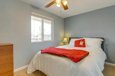 a bedroom with a bed with a red blanket on it at 12 Mi to Denver Golden Vacation Rental! in Golden
