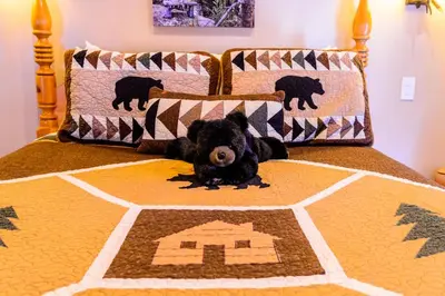 a small black dog laying on a bed at Alpen Way Chalet Mountain Lodge in Evergreen