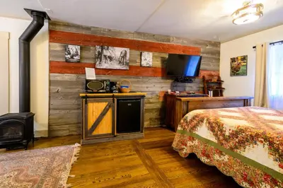 a hotel room with a bed and a tv at Alpen Way Chalet Mountain Lodge in Evergreen