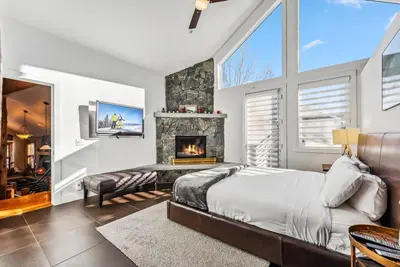 a bedroom with a bed and a fireplace at Luxurious 4BR Retreat with Hot Tub Near Gold Course in Breckenridge