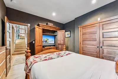 a bedroom with a bed and a flat screen tv at Luxurious 4BR Retreat with Hot Tub Near Gold Course in Breckenridge