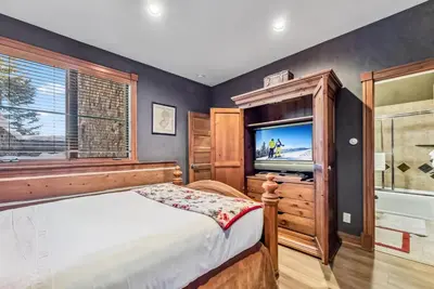 a bedroom with a bed and a flat screen tv at Luxurious 4BR Retreat with Hot Tub Near Gold Course in Breckenridge