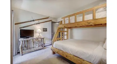 a bedroom with a bunk bed and a television at Updated 2Br Plus Loft Condo on Shuttle Route! Sleeps 8 & Kids Ski Free condo in Montezuma