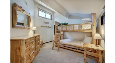 a bedroom with bunk beds and a desk and a mirror at Updated 2Br Plus Loft Condo on Shuttle Route! Sleeps 8 & Kids Ski Free condo in Montezuma