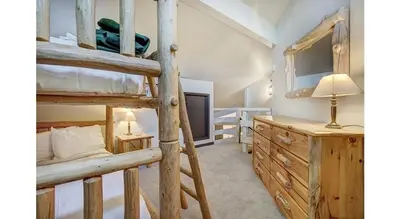 a bedroom with two bunk beds and a desk at Updated 2Br Plus Loft Condo on Shuttle Route! Sleeps 8 & Kids Ski Free condo in Montezuma