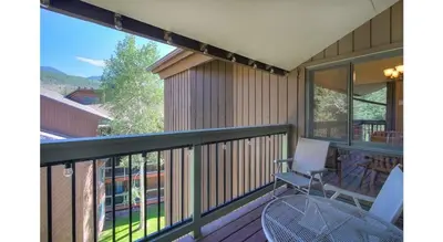 a balcony with a table and chairs on a house at Updated 2Br Plus Loft Condo on Shuttle Route! Sleeps 8 & Kids Ski Free condo in Montezuma