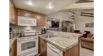 a kitchen with a sink and a stove top oven at Updated 2Br Plus Loft Condo on Shuttle Route! Sleeps 8 & Kids Ski Free condo in Montezuma