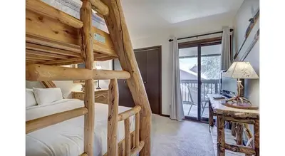 a bedroom with two bunk beds and a desk at Updated 2Br Plus Loft Condo on Shuttle Route! Sleeps 8 & Kids Ski Free condo in Montezuma