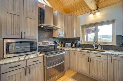 a kitchen with wooden cabinets and stainless steel appliances at Mountain-View Front Range Colorado Vacation Rental in Red Feather Lakes