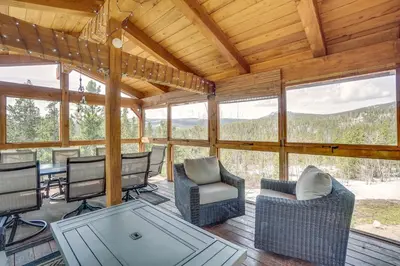 a screened in porch with chairs and a table at Mountain-View Front Range Colorado Vacation Rental in Red Feather Lakes