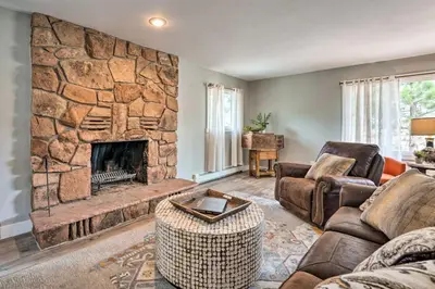 a living room with a large stone fireplace at 4 bed 2 bath home located near Rocky Mountain National Park in Estes Park