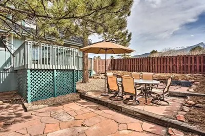 a patio with a table and chairs and an umbrella at 4 bed 2 bath home located near Rocky Mountain National Park in Estes Park