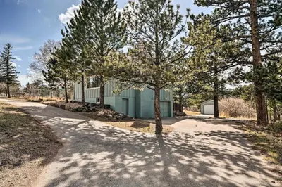 a house with a tree in the middle of a road at 4 bed 2 bath home located near Rocky Mountain National Park in Estes Park