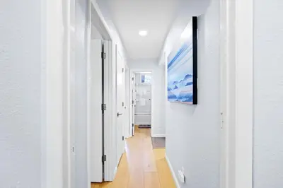a hallway with white walls and a painting on a wall at Stunning 3BR central to Breck Keystone Copper in Silverthorne