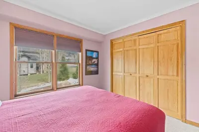 a bedroom with a pink bed and a large window at Homey 3BR Near Lake Dillon with Mountain Views in Dillon