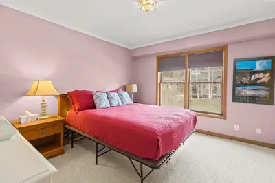 a bedroom with a red bed and a window at Homey 3BR Near Lake Dillon with Mountain Views in Dillon