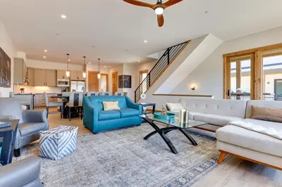 a living room with couches and a table at Fraser Getaway with Deck Near Winter Park Resort! in Fraser