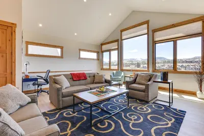 a living room with a couch and chairs and windows at Fraser Getaway with Deck Near Winter Park Resort! in Fraser