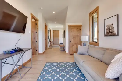 a living room with a couch and a table at Fraser Getaway with Deck Near Winter Park Resort! in Fraser