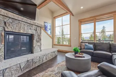 a living room with a large stone fireplace at Incredible 3BR Tranquil Setting & Space to Spare in Silverthorne
