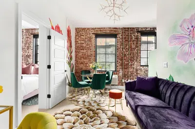 a living room with a purple couch and a bedroom at The Acoma House in Denver