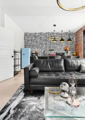a living room with a black leather couch at The Acoma House in Denver