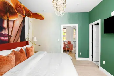 a bedroom with a white bed and green walls at The Acoma House in Denver