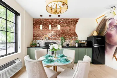 a kitchen with a table with chairs and a brick wall at The Acoma House in Denver