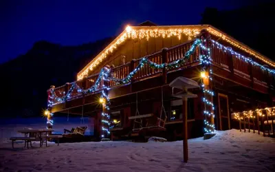 a building with christmas lights on it in the snow at McGregor Mountain Lodge in Estes Park