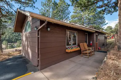 a small cabin with a porch and a patio at McGregor Mountain Lodge in Estes Park
